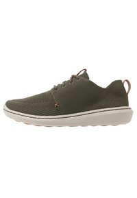 Sneakers verde oliva realizzati in rete traspirante con superficie texturizzata, caratterizzati da una suola bianca e dettagli di lacci marroni.