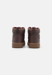 Brązowe skórzane sneakersy typu high-top z teksturowanymi bokami, z gumowymi podeszwami i pętlami z tyłu, z małym złotym logo.