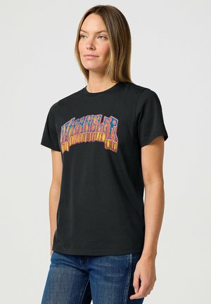 Zwarte katoenen T-shirt met een meerkleurige "Wrangler"-graphic met een retro ontwerp, korte mouwen en een klassieke ronde hals.
