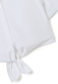 Witte blouse met korte mouwen, een knoopsluiting aan de voorkant en een gestrikt detail aan de onderkant. Gemaakt van een lichte, gladde stof.