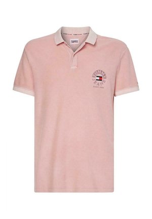 Jasnoróżowa koszulka polo z krótkim rękawem, białym kołnierzykiem i lamówką na rękawach, z logo Tommy Jeans i emblematem flagi na piersi.