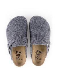 Les sabots gris présentent une forme arrondie, une boucle réglable et une semelle intérieure douce avec une doublure intérieure beige et un logo noir sur la semelle extérieure.