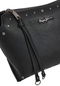 Bolsa de couro texturizado preto com tachas prateadas, puxadores de zíper pretos e um logotipo metálico "Pepe Jeans" na parte da frente.