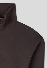Maglione marrone scuro con colletto alto e cerniera. Realizzato in tessuto liscio, presenta cuciture pulite e una vestibilità aderente attorno al collo.