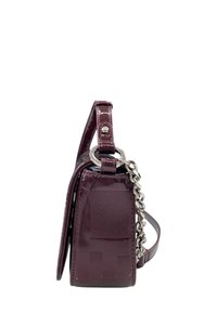 Borsa a mano in pelle verniciata bordeaux con forma rettangolare, dotata di tracolla a catena removibile e dettagli testurizzati sul corpo.
