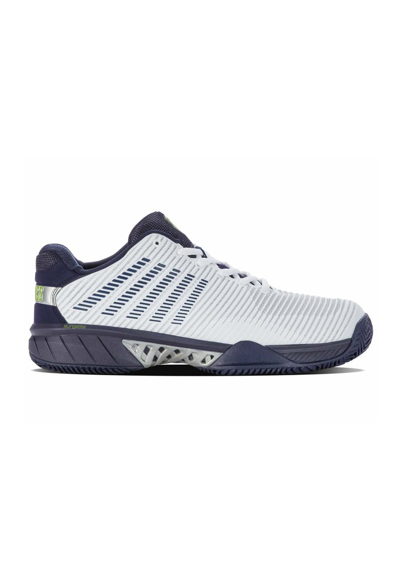 Scarpa sportiva bianca e blu navy con una tomaia sintetica texurizzata, dettagli in rete e una suola robusta con un motivo a tasselli geometrico.