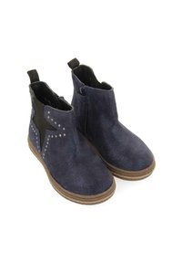 Botas de tobillo de ante en color marino con detalle de estrella negra, tachuelas plateadas, cremallera lateral y suela de goma marrón. Cuenta con lengüetas para facilitar su uso.