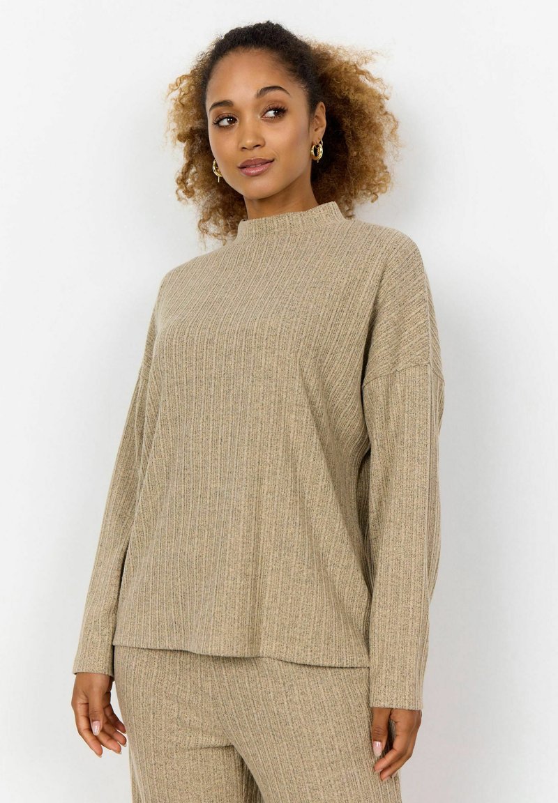Beige gerippter Pullover mit hohem Kragen und langen Ärmeln, der eine lockere Passform und eine subtile Textur im gesamten Stoff aufweist.