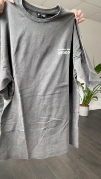 Gray cotton t-shirt featuring short sleeves, a crew neck, and a graphic print reading "PHASES OF THE MOON" in white on the chest.