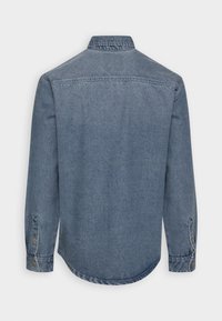 Langärmliges Denim-Hemd in verblasstem Blau, von hinten gezeigt, mit geknöpften Manschetten und klassischem Kragen auf einem schlichten Hintergrund.