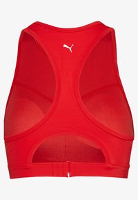 Raudonas sportinis liemenukas su racerback dizainu, pagamintas iš lengvos medžiagos, turintis tinklines detales ir mažą baltą logotipą viršuje nugaros.