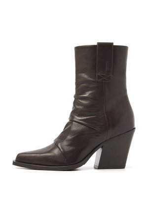 Dark brown mid-calf leather boot with a slouched design and a chunky angled heel on a white background.