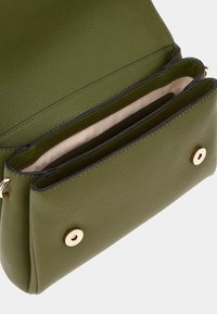 Borsa a tracolla in pelle verde con una finitura testurizzata, caratterizzata da un interno beige, numerosi scomparti e dettagli in metallo dorato.