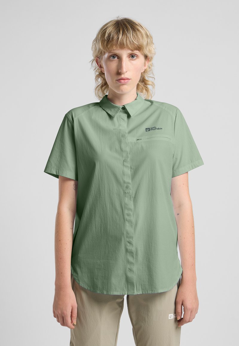 Camicia verde chiaro a maniche corte con colletto button-down, tessuto testurizzato, taschino frontale e dettaglio del logo sul lato sinistro.