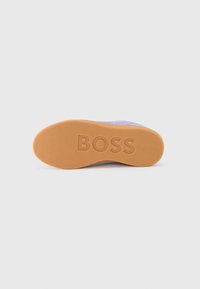 Podplat superge iz svetlo rjavega gumijastega materiala z izbočeno oznako "BOSS". Ima teksturirano površino in zaobljene robove za boljši oprijem. Lahka in trpežna zasnova.