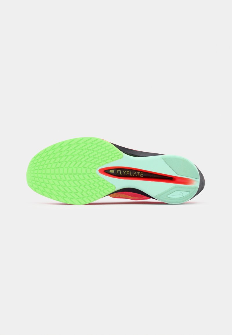 Suela de zapatilla deportiva con goma verde y un patrón texturizado, entresuela de color menta y acentos en negro y rojo.