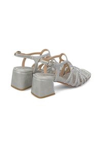 Srebrne sandały na obcasie z paskami, z blokowym obcasem, posiadające teksturowaną cholewkę oraz zapięcie na klamrę. Gładkie wnętrze z lekkim wyściółkowaniem.