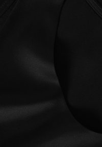 Zwart stof met een gladde, matte textuur, met een lichte glans en subtiele plooien, wat wijst op een lichtgewicht materiaal. Geen patronen of hardware zichtbaar.