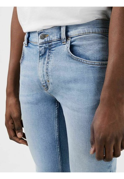 Lichtblauwe denim jeans met een slim fit, voorzien van voorkruiszakken, een knoopsluiting en subtiele vervaging. Zachte textuur, zichtbare stikdetails.