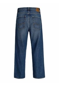 Jean droit bleu foncé vus de l'arrière avec deux poches arrière et une étiquette en cuir marron de la marque sur la taille.