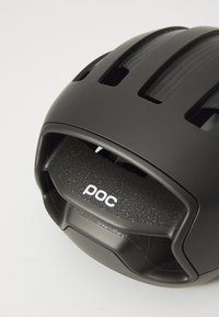 Cască de ciclism neagră cu design aerodinamic, multiple sloturi de ventilație, amortizare interioară texturată și logo "poc" pe spate.