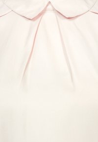 Blush pink bluse med rund krave, som har læg ved halsudskæringen. Lavet af glat stof med en subtil glans og rene sømme.