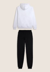 Un sweat à capuche blanc avec une poche kangourou et un pantalon de survêtement noir avec une taille élastique et des poignets, présenté sur un fond neutre.