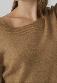 Pull en maille marron avec un col large à côtes et une texture douce, présentant un design d'épaule légèrement courbé.