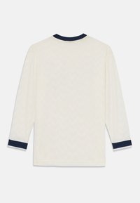 Langarmshirt in crèmekleur met een textuur chevronpatroon en een marineblauwe kraag en manchetten. Zachte stof met een ontspannen pasvorm.