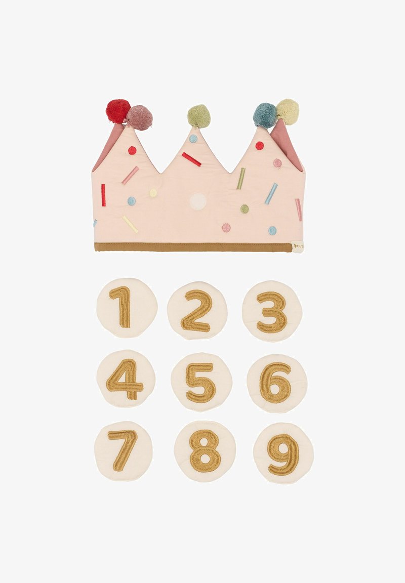 Rozā kronis ar pom-pomiem un krāsainiem pārklājumiem, kopā ar deviņiem apaļiem auduma diskiem, kuros ir zelta izšūti cipari no 1 līdz 9.
