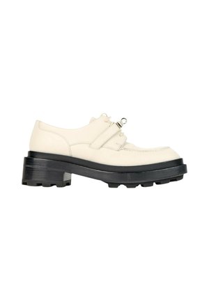 Off-white lædersko med tyk sort sål med groft mønster, chunky hæl, snøre foran og en dekorativ rem med metaldetalje tværs over toppen.