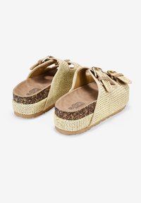 Sandalias de plataforma destalonadas con parte superior de tejido beige, plantilla marrón y media suela de corcho texturizado. Presenta dos correas con hebillas para un ajuste seguro.