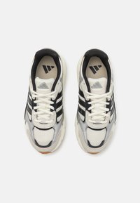 Sneaker mit einem Obermaterial aus Mesh in Creme, schwarzen Streifen und silbernen Akzenten. Schnürdesign mit einer gepolsterten Sohle und Logo auf der Zunge.