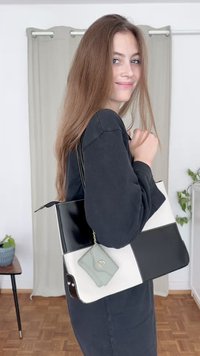 Μαύρη και λευκή τσάντα ώμου με ορθογώνιο σχήμα, που διαθέτει υφή στην επιφάνεια της και μια μικρή τσέπη σε μέντα πράσινο χρώμα. Παρουσιάζεται επίσης αλυσιδίτσα ως διακόσμηση.