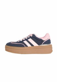 Sinine sametist sneaker, roosa aktsentidega, kolme valge triibuga, paksu kummitaldiga, ümmarguse varbaga ja paelte ühendusega disain. Omab hõbedast riistvara detaile.