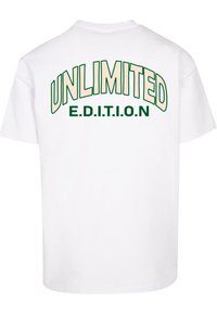 Fehér pamut póló zöld és krém színű felirattal a hátsó oldalon. A felirat olvasható: "UNLIMITED" egy vastag ívben, alatta pedig "E.D.I.T.I.O.N".