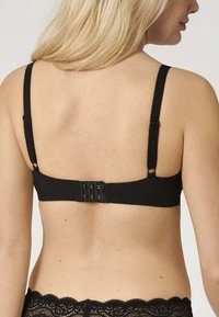 Reggiseno nero con spalline regolabili, chiusura con gancio e occhiello e dettagli in pizzo lungo la fascia. Tessuto liscio con bordi scallop.