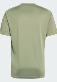 Camiseta de manga corta en verde oliva claro, hecha de un tejido suave con escote redondo y sin adornos visibles. Diseño limpio y minimalista.