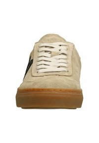 Beige suède sneakers met witte veters en een zwart logo. Beschikt over een rubberen buitenzool met een textuurpatroon en verstevigde stiksels.