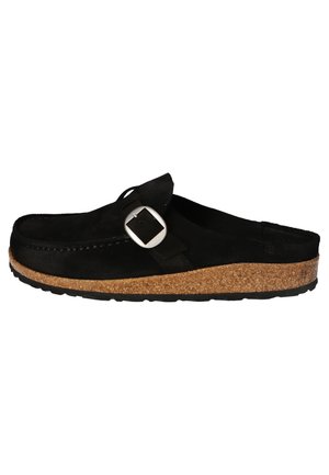 Sabot en cuir de suède noir avec une forme courbée, présentant un accent en boucle en argent et une semelle en liège, une semelle en caoutchouc texturé noir et une ouverture sur le côté.