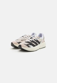 Sneakers with a beige suede and mesh upper, featuring black stripes, white laces, and a chunky white midsole. Textured rubber outsole.