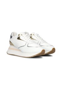 White leather sneakers with metallic gold accents, rounded toe, and a thick cream wedge sole with textured brown outsole. Lace-up design.