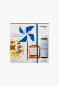 Korres Lefko cadeau set met een amberglazen fles Eau de Toilette, douchegel in een slanke zwarte fles, en kleurrijke verpakking met een wervelwind.