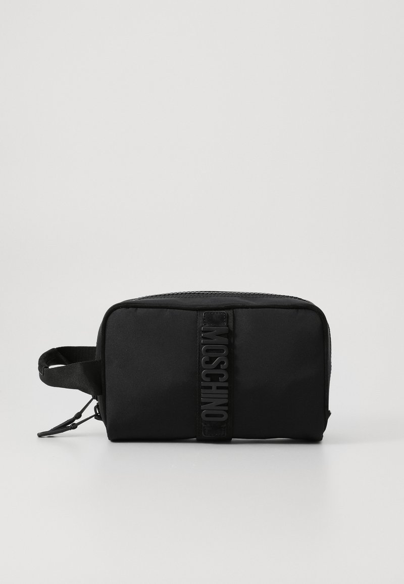 Fekete szövet neszeszer, amely téglalap alakú, kiemelkedő, mélyen nyomott logós pánttal és cipzáros záródással rendelkezik. Oldalsó fogantyúval rendelkezik.