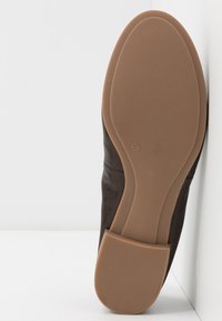 Sole di scarpa in pelle marrone con superficie liscia e una sottile texture. Design piatto, con punta arrotondata e suola in gomma flessibile. Taglia 37.