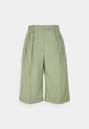 Vaaleanvihreät pitkähameiset shortsit, joissa on korkea vyötärö, leveä lahkeensuun malli ja sileästi teksturoitu kangas. Edessä vasemmalla puolella on yksi tasku.