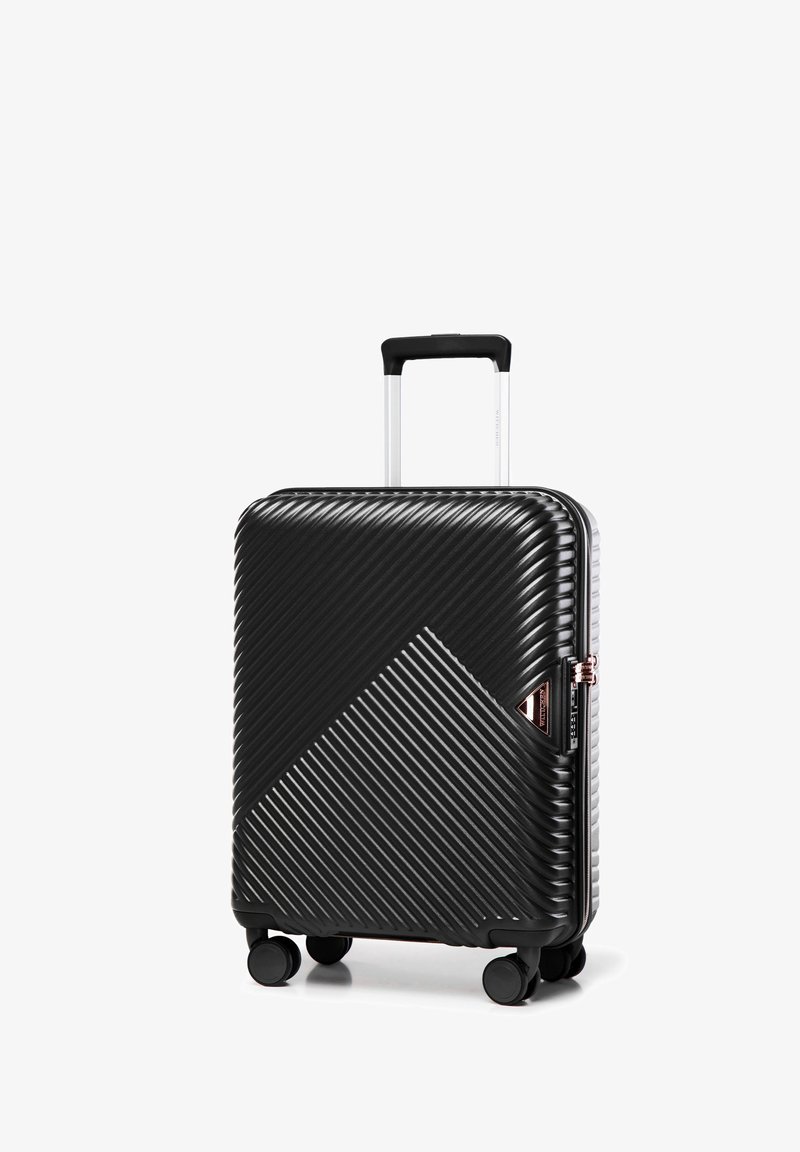 Valigia rigida nera con texture a righe diagonali, manico telescopico argento, quattro ruote e zip e dettagli color oro rosa.