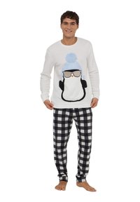 Felpa bianca con grafica di un pinguino con occhiali e cappello con pon pon blu, abbinata a pantaloni da pigiama a scacchi bianchi e neri.