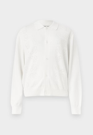 Biely zapínací kardigán s dlhými rukávmi a jemnými kvetinovými vzormi pletenými na predných paneloch.