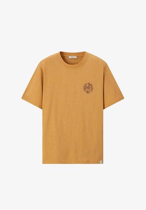 T-shirt jaune moutarde à manches courtes avec col rond et petit motif graphique sombre de feuilles et texte sur la poitrine gauche.